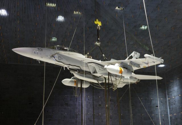 Two Next Generation Jammer Mid-Band pods, attached to an EA-18G Growler, undergo testing in the Air Combat Environmental Test and Evaluation Facility anechoic chamber at Naval Air Station Patuxent River.