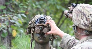 A 10th Mtn Soldier adjusts his Enhanced Night Vision Goggle - Binocular in preparation for a land navigation exercise