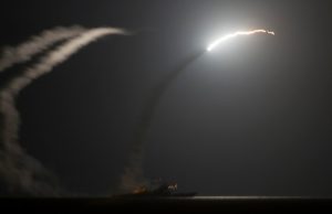 US destroyer launching missile at night