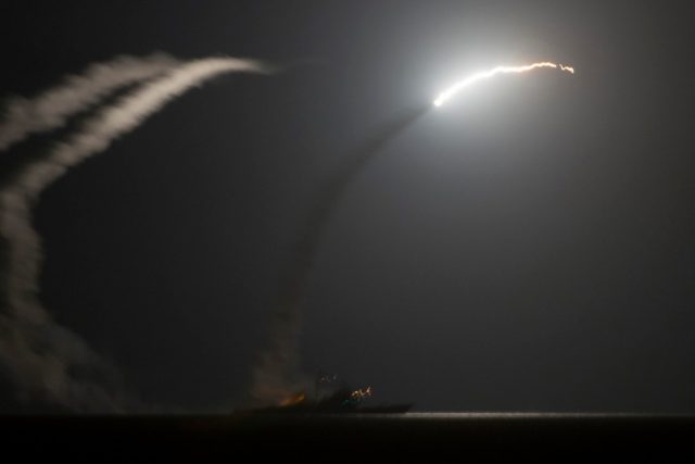 US destroyer launching missile at night