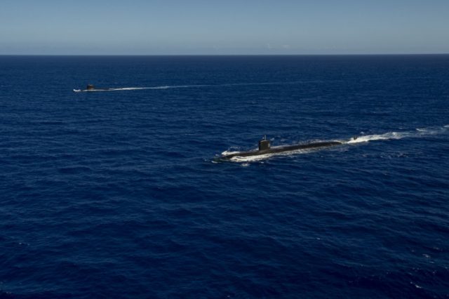 The Los Angeles-class fast-attack submarine USS Asheville (SSN 758), right, and the French Navy Rubis-class nuclear powered submarine (SSN) Émeraude steam in formation off the coast of Guam during a photo exercise. Asheville and Émeraude practiced high-end maritime skills in a multitude of disciplines designed to enhance interoperability between maritime forces. Asheville is one of four forward-deployed submarines assigned to Commander, Submarine Squadron 15