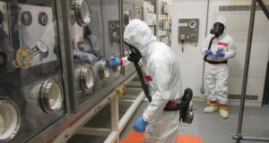 Sgt. Joshua Kamami, a Chemical, Biological, Radiological, Nuclear (CBRN) specialist for Nuclear Disablement Team 1, watches on as Nuclear Disablement Team 2 CBRN specialist Sgt. Shivam Patel runs a swipe across the surfaces of a glove port to check for the presence of radioactive contamination.